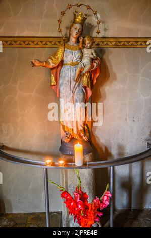 Marienfigur mit Krone, Jesuskind und Opferkerzen, Kirche St. Martin in Blaichach, Allgäu, Bayern, Deutschland Stockfoto