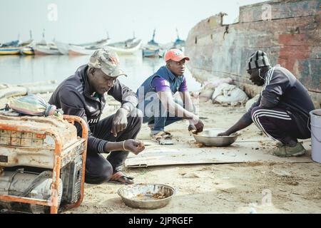 Fischer beim Mittagessen, Port de Peche Traditionelle, Nouadhibou, Mauretanien Stockfoto