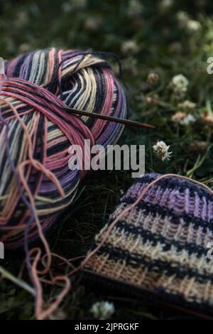 Strickstück mit Stricknadeln auf einer Wiese Stockfoto