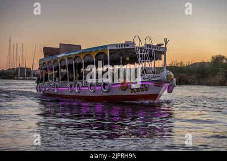 Beleuchtetes Ausflugsboot auf dem Nil bei Assuan, Ägypten Stockfoto