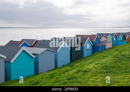 Blick von hinten auf eine Reihe von Strandhütten am Frinton on Sea in Essex UK Stockfoto