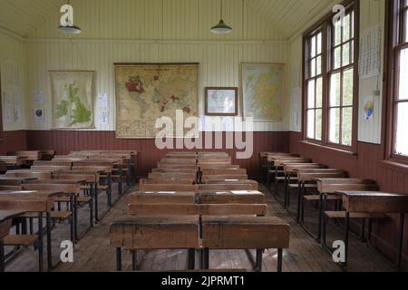 Eine Nahaufnahme von Holztischen und Stühlen in einem alten Klassenzimmer Stockfoto
