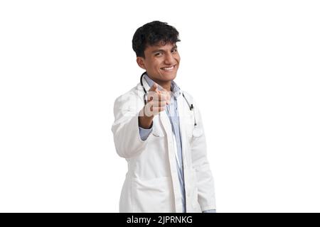 Porträt eines jungen peruanischen männlichen Arztes, der lächelt und auf die Kamera zeigt, isoliert. Stockfoto