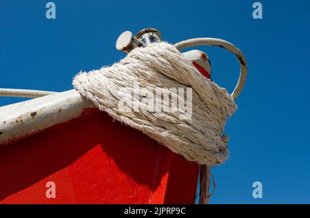 Nahaufnahme eines aufgespannten Vorwehens eines roten Schiffes vor blauem Himmel Stockfoto