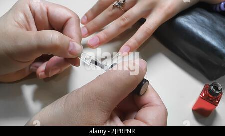 Schritt-für-Schritt-Anleitung zur Nagelverlängerung auf Gelspitzen. Maniküre, Hände im Vordergrund. Kopierraum Stockfoto