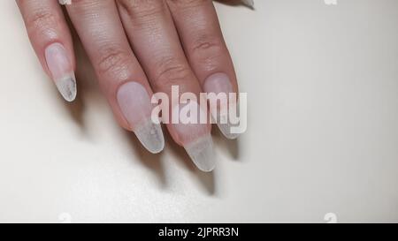 Schritt-für-Schritt-Anleitung zur Nagelverlängerung auf Gelspitzen. Maniküre, Hände im Vordergrund. Kopierraum Stockfoto