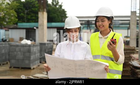 Asiatische weibliche Aufsichtsperson und Architekt Prüfplan Inspektion kommerziellen Baustellen Stockfoto