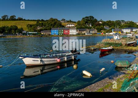 Bantry, Irland -12. August 2022: Kleine hölzerne Ruderboote und Fischernetze und Krabbenfallen in der Bantry Bay im Hintergrund mit der Innenstadt von Bantry Stockfoto