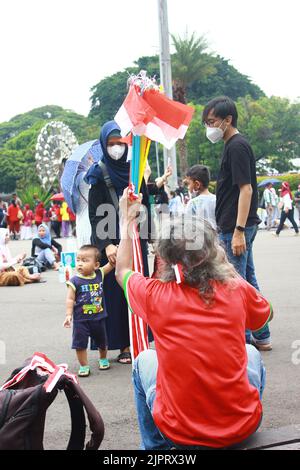 Indonesien, Jakarta, 17/08/2022 - Straßenverkäufer, der während der indonesischen Unabhängigkeitstag-Fest 77. nationale Flagge aus Kunststoff verkauft Stockfoto