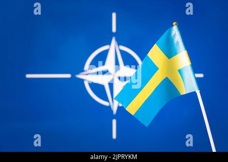 Flagge Schwedens und die Flagge der NATO, der größten Verteidigungsallianz der Welt, das Konzept der Erweiterung der Grenzen des Nordatlantikbündnisses wi Stockfoto
