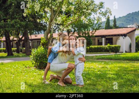 Glückliche Familie im Freien auf dem Gras in einem Park, lächelnde Gesichter, Spaß habend Porträt eines verärgerten Mädchens, das an einem Kaffeetisch sitzt Stockfoto