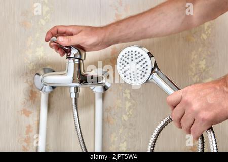 Klempner verbunden Duschkopf mit flexiblem Schlauch zu Einhebel Wasserhahn im Badezimmer. Stockfoto