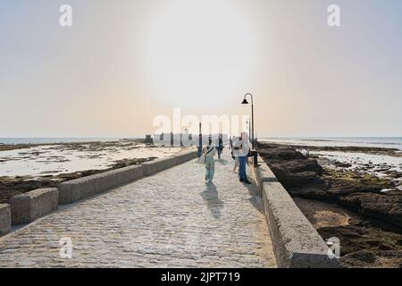 CÁDÁZ, SPANIEN -15. APRIL 2022: Paseo Fernando Quiñones Umgeben von Strand fast ohne Menschen mit der Burg von San Sebastián im Hintergrund Stockfoto