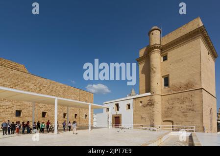 CÁDÁZ, SPANIEN - 15. APRIL 2022: Touristengruppe in der Iglesia de la Santa Cruz oder der alten Kirche mit dem Turm des Sagrario in Cádáz. Stockfoto