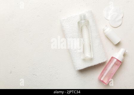Micellar Reinigungswasser und Scheiben zur Entfernung von Kosmetika und zur Reinigung der Haut auf farbigem Hintergrund. Obere Ansicht des Kopierbereichs. Stockfoto