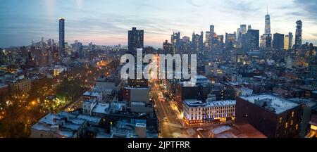 Panoramablick auf die Skyline von New York City mit den Abendlichtern der Gebäude, die über das Stadtbild leuchten Stockfoto