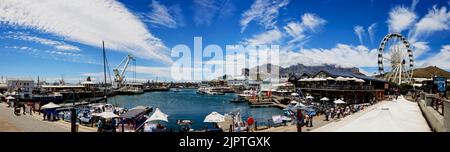 Ein Panoramablick auf die V&A Waterfront mit Tafelberg im Hintergrund mit Schiffen und Touristen Stockfoto