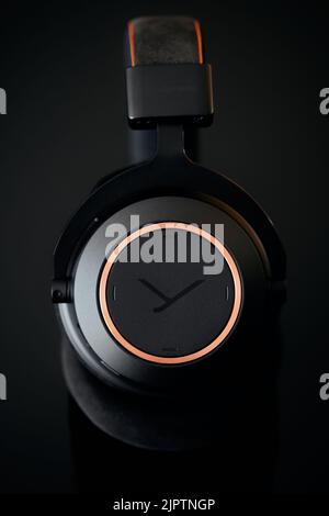 Eine Nahaufnahme eines der Ohrmuscheln der kabellosen Kopfhörer Beyerdynamic Amiron auf schwarzem Hintergrund Stockfoto