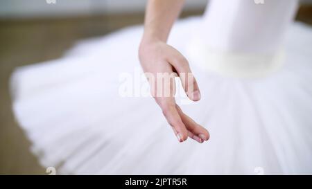 Im Ballettsaal führt die junge Ballerina Allonge vor, die Hand bewegt sich elegant, Nahaufnahme. Hochwertige Fotos Stockfoto