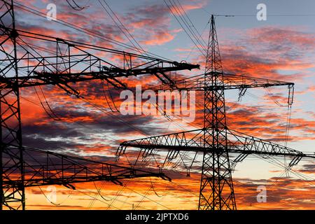 Viele elektrische Pole vor dem Himmel mit Wolken Stockfoto