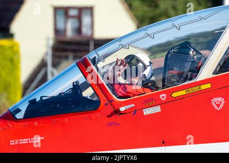 London Southend Airport, Essex, Großbritannien. 20. August 2022. Die Red Arrows der RAF nutzen den zivilen Flughafen für die Airshows dieses Wochenendes in Eastbourne und Folkestone. Die roten Pfeile sind am späten Nachmittag geflogen und kommen in ihrer berühmten Pfeilformation zurück, bevor sie an Land gehen. Viele Menschen sind hinausgekommen, um sie zu sehen und säumen die Zäune. Der rote 1-Teamleiter Tom Bould, Anführer der Geschwader, winkt der Menge zu Stockfoto