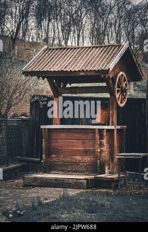 Ein alter hölzerner Ziehbrunnen in einer ländlichen Gegend Stockfoto