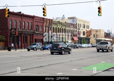 DETROIT, MICHIGAN, VEREINIGTE STAATEN - 22. MAI 2018: Straße mit Ampeln, Autos und niedrigen Häusern mit Geschäften in einem Vorort von Detroit Stockfoto