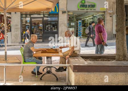 Jerusalem, Israel - 2.. Juni 2022: Zwei ältere Männer spielen Backgammon auf einer Straße in Jerusalem, Israel. Stockfoto