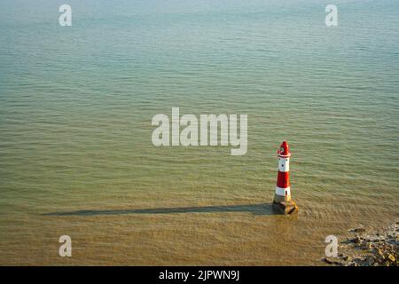 Beachy Head Lighthouse, umgeben von Wasser in der Nähe von Eastbourne an einem sonnigen Tag im Mai, East Sussex, England, Großbritannien Stockfoto