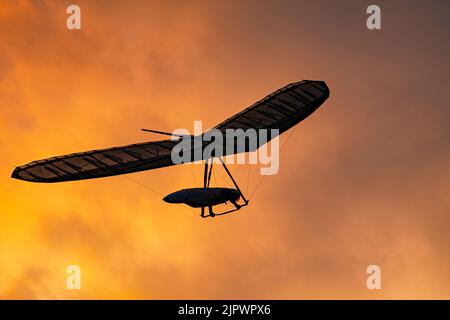 Sport Hang Segelflugzeug Flügel Silhouette auf dem brennenden Sonnenuntergang Himmel Stockfoto