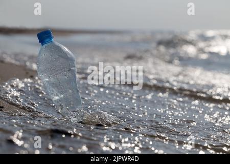 Nahaufnahme von Plastikflaschen am Strand. Stockfoto