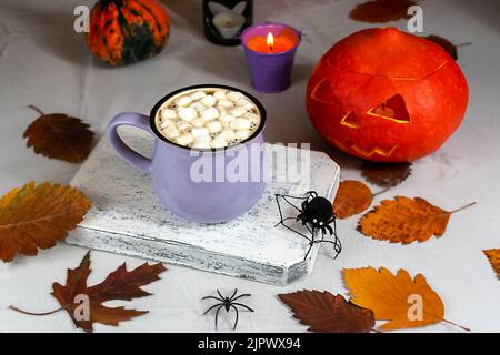 Stillleben im Herbst mit Kürbissen, Kerzen, Blättern und einer Tasse Kaffee auf dem Tisch. Selektiver Fokus. Halloween-Konzept. Stockfoto