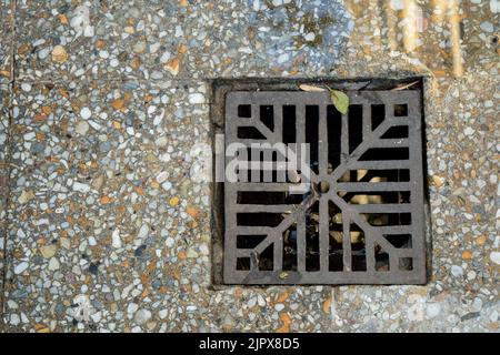 Granitmosaikboden. Baumaterialien Sturmabflussgitter Stockfoto