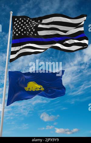 Dünne blaue Linie Flagge der USA mit kleinerer Flagge des Staates Oregon, USA bei bewölktem Himmel Hintergrund. Vereinigte Staaten von Amerika Polizeiflagge. Platz für Vertic kopieren Stockfoto