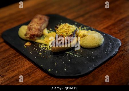 Spanische Pintxos aus dekonstruierten, angebratenen Foie Gras stoßen mit einer Trüffelcreme in einem Restaurant in San Sebastian Donostia, Baskenland, Spanien, an Stockfoto