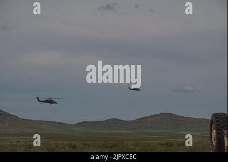 Zwei HH-60G Pave Hawks, die dem Rettungsgeschwader 55. zugewiesen wurden, fliegen über einen Übungsplatz im Playas Training Center, New Mexico, 11. August 2022. Der Luftwaffenstützpunkt Davis-Monthan ist die einzige Anlage, die RF-R beherbergt RF-R wird zweimal im Jahr veranstaltet und umfasst verschiedene amerikanische Einheiten sowie verschiedene Partner-Kräfte. (USA Luftwaffe Foto von Senior Airman Kaitlyn Ergish) Stockfoto