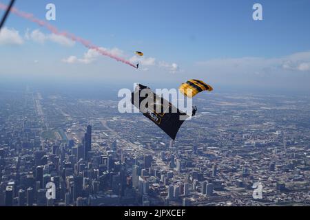 Personal Sgt. Nahu Ramirez vom US Army Fallschirmteam macht am 19. August 2022 einen Übungsdemonstrationssprung mit dem Army Star Drop Banner in Chicago, Illinois, während sein Teamkollege Staff Sgt. Logan Maples, fliegt entlang. Das US Army Fallschirmteam tritt am 20-21. August für die Chicago Air and Water Show auf. (USA Foto der Armee von Staff Sgt. Jason Bauder) Stockfoto