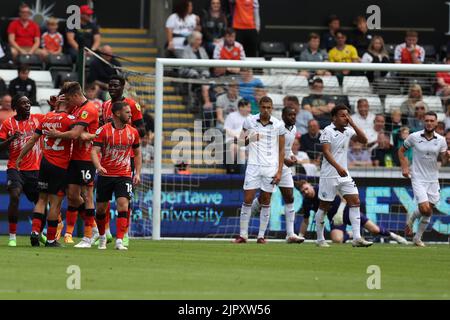 Swansea, Großbritannien. 20. August 2022. Die Spieler von Swansea City sehen niedergeschlagen aus, als Allan Campbell von Luton Town (22) mit seinen Teamkollegen feiert, nachdem er ihr Tor von 1. erzielt hat. EFL Skybet Championship match, Swansea City gegen Luton Town im Swansea.com Stadium in Swansea, Wales am Samstag, 20.. August 2022. Dieses Bild darf nur für redaktionelle Zwecke verwendet werden. Nur zur redaktionellen Verwendung, Lizenz für kommerzielle Nutzung erforderlich. Keine Verwendung in Wetten, Spiele oder einem einzigen Club / Liga / Spieler Publikationen. PIC von Andrew Orchard / Andrew Orchard Sport Fotografie / Alamy Live News Kredit: Andrew Orchard Sport Fotografie / Alamy Live News Stockfoto