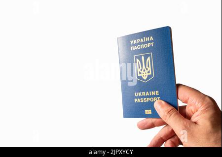 Ukrainischer biometrischer Pass in weiblicher Hand auf weißem Hintergrund. Minimalismus. Es ist freier Speicherplatz zum Einfügen vorhanden. Identifikation, Patriotismus, Demokratie, Stockfoto