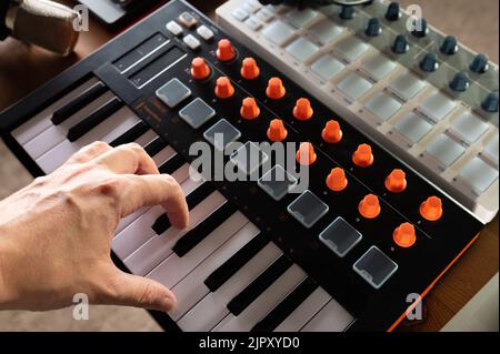 Nahaufnahme. Moderne Midi-Tastatur. Professionelle Ausrüstung für Aufnahmestudio, Musikstudio. Professionelle Tätigkeit eines Toningenieurs, Musikers, Kompos Stockfoto