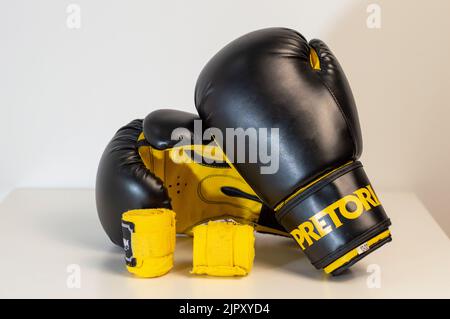 Nahaufnahme Von Schwarzen Boxhandschuhen Gegen Weißen Hintergrund. Paar schwarze Boxhandschuhe isoliert auf weißem Hintergrund Stockfoto
