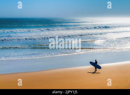 Surfen Sie am Strand und beobachten Sie die ankommenden Wellen Stockfoto