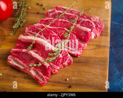 Hausgemachte Steaks mit einem Rosmarinzweig auf einem Holzhintergrund. Minimalismus. Home Kochen Rezepte, Lebensmittel-Blog, Kochbuch, Lebensmittel-Blog. Es gibt keine Menschen Stockfoto
