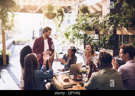 Das Mittagessen ist auf mich zu sagen, danke für die harte Arbeit. Eine Gruppe von kreativen Mitarbeitern, die ein Treffen während des Mittagessens in einem Café. Stockfoto