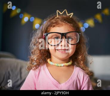 Shes a cutie. Portrait eines entzückenden kleinen Mädchens, das zu Hause verkleidet spielt. Stockfoto