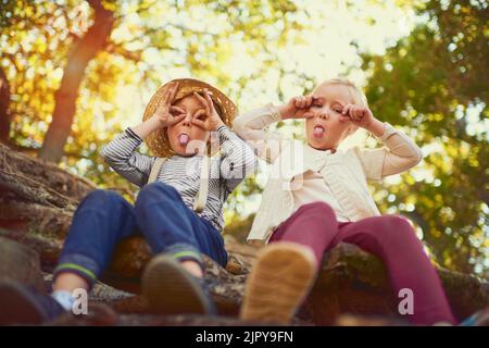 Sie sind einfach nur dumm. Portrait von zwei kleinen Kindern, die im Freien spielen. Stockfoto