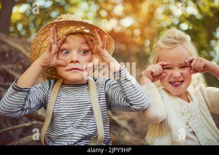 Sie zeigen ihren lustigen Charakter. Portrait von zwei kleinen Kindern, die im Freien spielen. Stockfoto