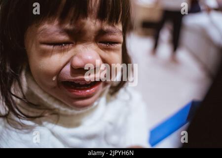 Kleinkind weint und Tränen laufen über ihre Wange Stockfoto