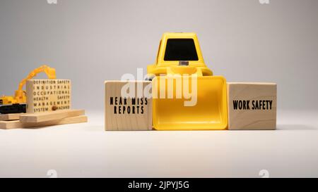 Beinahemiss-Berichte, Arbeitssicherheit, geschrieben auf Holzstäben. Business-Maschine und weißes Hintergrundkonzept. Arbeitssicherheit und Industrie. Stockfoto