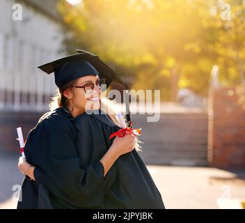 Ich bin so stolz darauf, wie weit wir gekommen sind. Zwei Studenten umarmen sich am Abschlusstag. Stockfoto